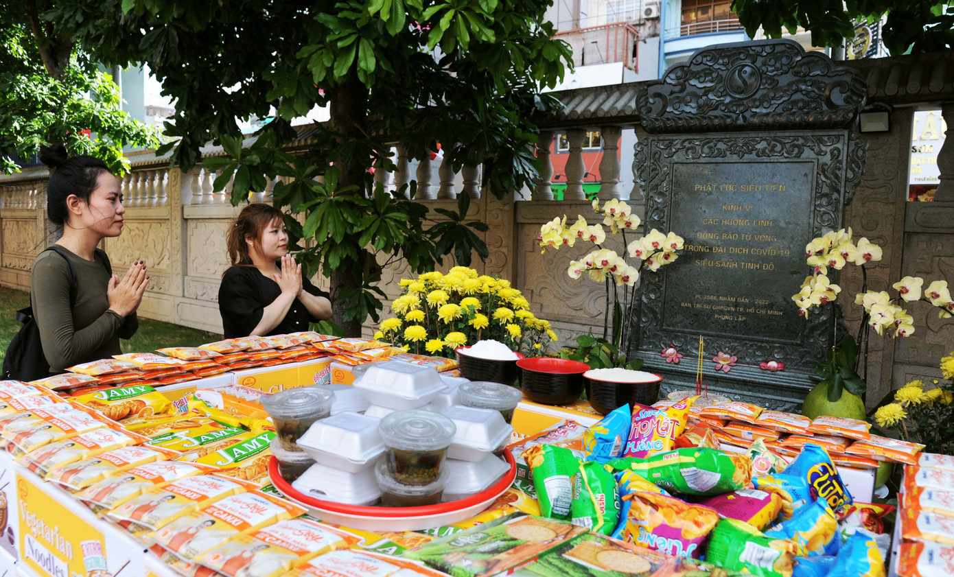 Các bạn trẻ tới dâng hương. Bạn Thủy (phải) nói: "Chúng em biết chùa Việt Nam Quốc Tự có bia tưởng niệm các liệt sĩ hy sinh trong đại dịch COVID-19 nên rằm tháng Giêng tới đây dâng lễ tưởng nhớ những người đã xả thân vì cộng đồng, vì đất nước. Em nghĩ mọi người sẽ không quên họ".