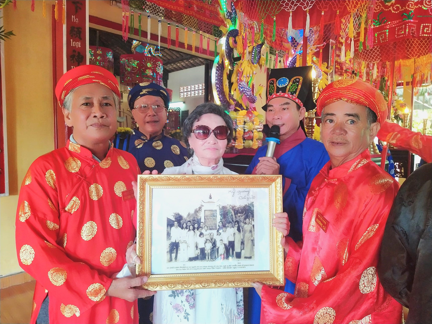 Nhà nghiên cứu Châu Anh Phụng (giữa) tặng các tài liệu về Nguyễn Đình Chiểu và Văn tế Nghĩa sĩ Cần Giuộc cho đình Tân Kim trong ngày hội đình làng.