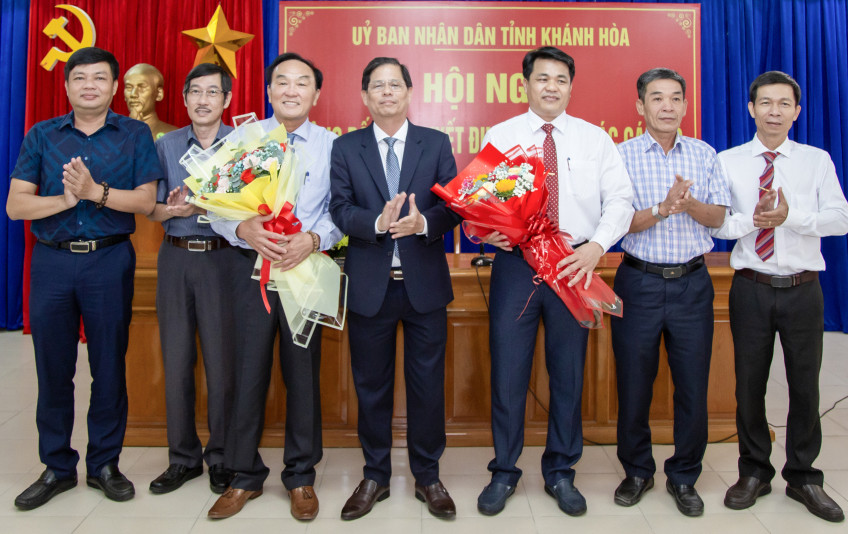 Ông Nguyễn Tấn Tuân - Chủ tịch UBND tỉnh Khánh Hoà, trao quyết định bổ nhiệm cho ông Nguyễn Duy Quang (thứ 3 bên phải) và trao quyết định nghỉ hưu cho ông Lê Tấn Bản (thứ 3 bên trái). Ảnh: C.Đ.