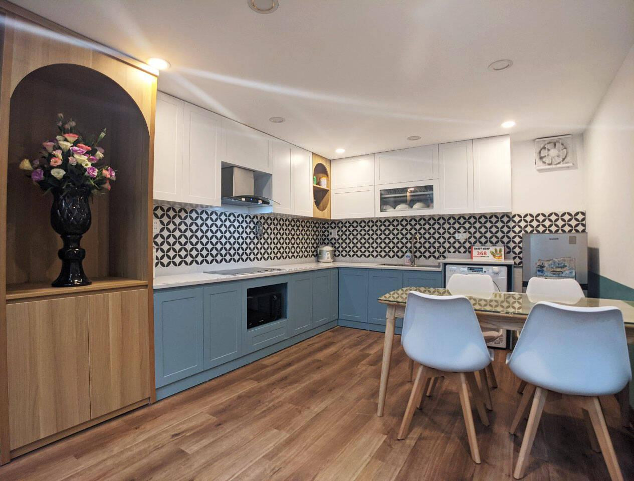 Không gian phòng bếp kiêm phòng ăn gọn gàng, ngăn nắp nhờ hệ tủ bếp tích hợp thông minh, tiện lợi.