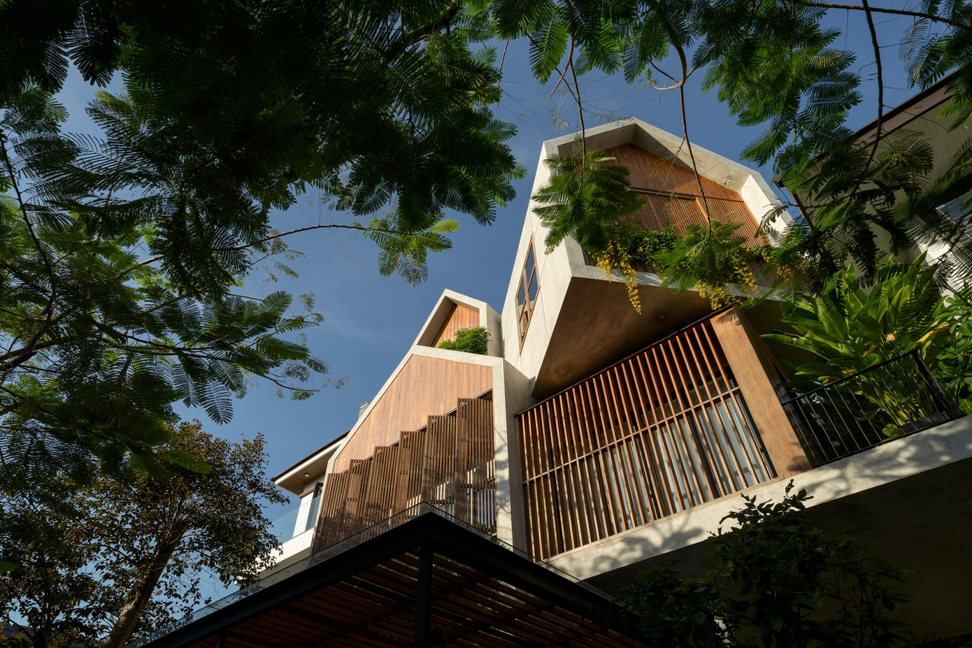 Hệ thống che nắng bằng gỗ linh hoạt kết hợp với nhiều loại cây xanh tạo nên những chuyển động thú vị trong ngày cũng như sự hài hòa với cảnh quan xung quanh.