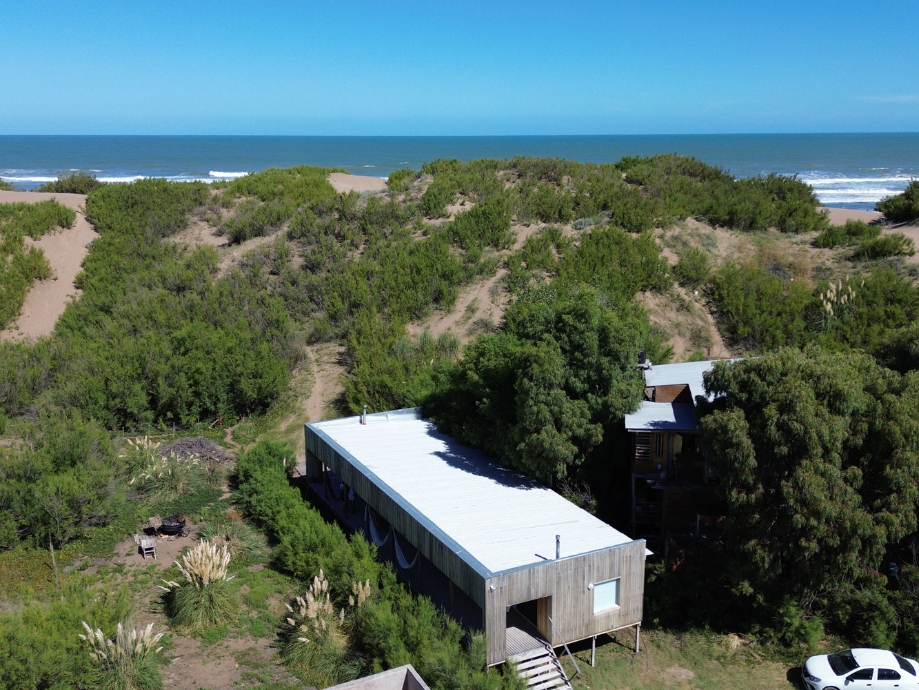 Kiến trúc sư lựa chọn lô đất xây nhà ở khu vực cồn cát có nhiều cây nhỏ bao quanh. Việc này nhằm bảo vệ ngôi nhà khỏi những cơn gió mang theo bão cát từ phía Tây Nam mạnh. Kiến trúc sư lựa chọn lô đất xây nhà ở khu vực cồn cát có nhiều cây nhỏ bao quanh. Việc này nhằm bảo vệ ngôi nhà khỏi những cơn gió mang theo bão cát từ phía Tây Nam mạnh.