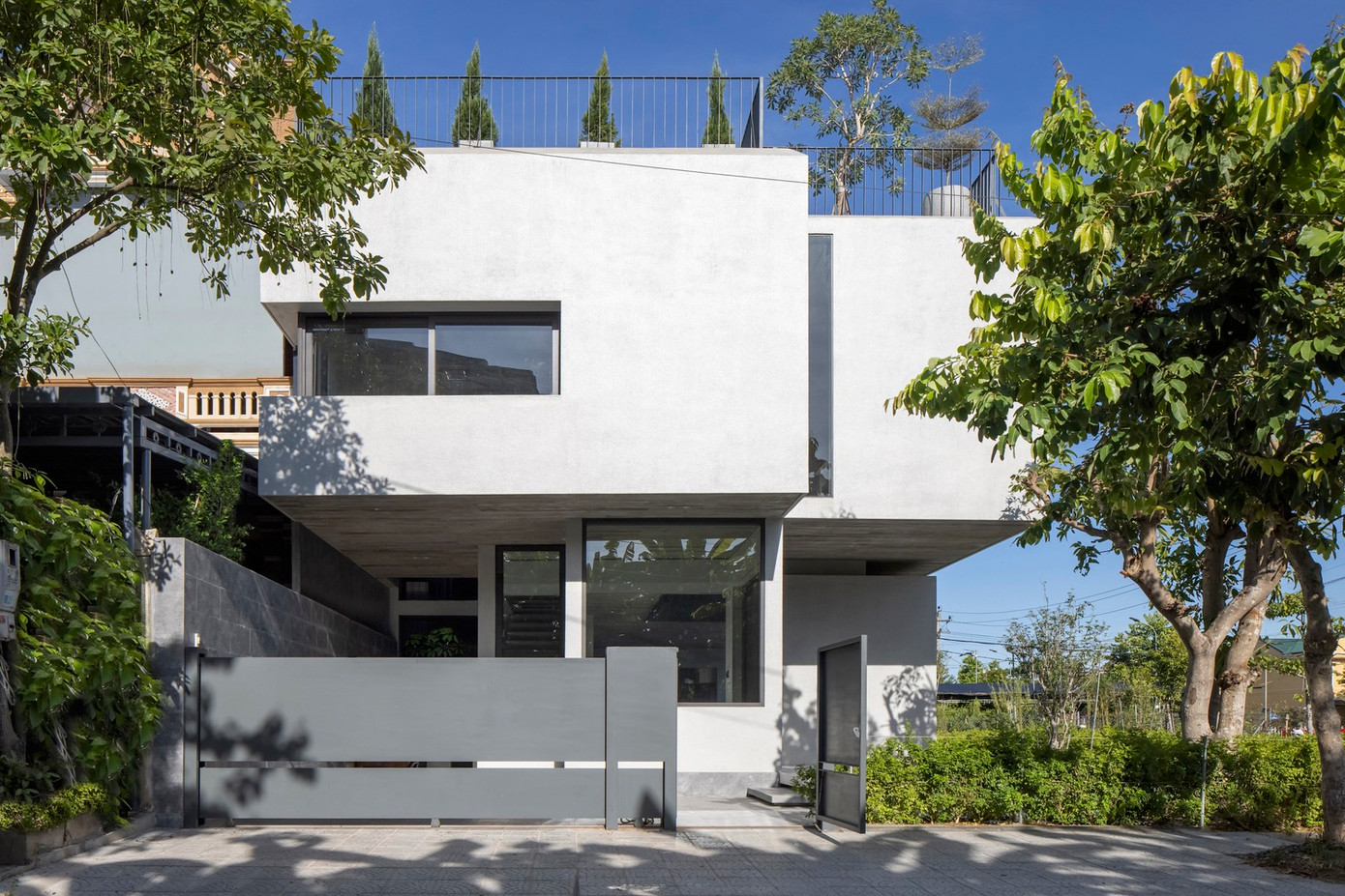 Khối dưới của ngôi nhà, trải dài dọc theo khu vườn, ôm trọn cây xanh, trong khi khối trên có quy mô lớn hơn, đóng vai trò như một lớp vỏ bảo vệ, che chắn khối dưới khỏi các yếu tố.