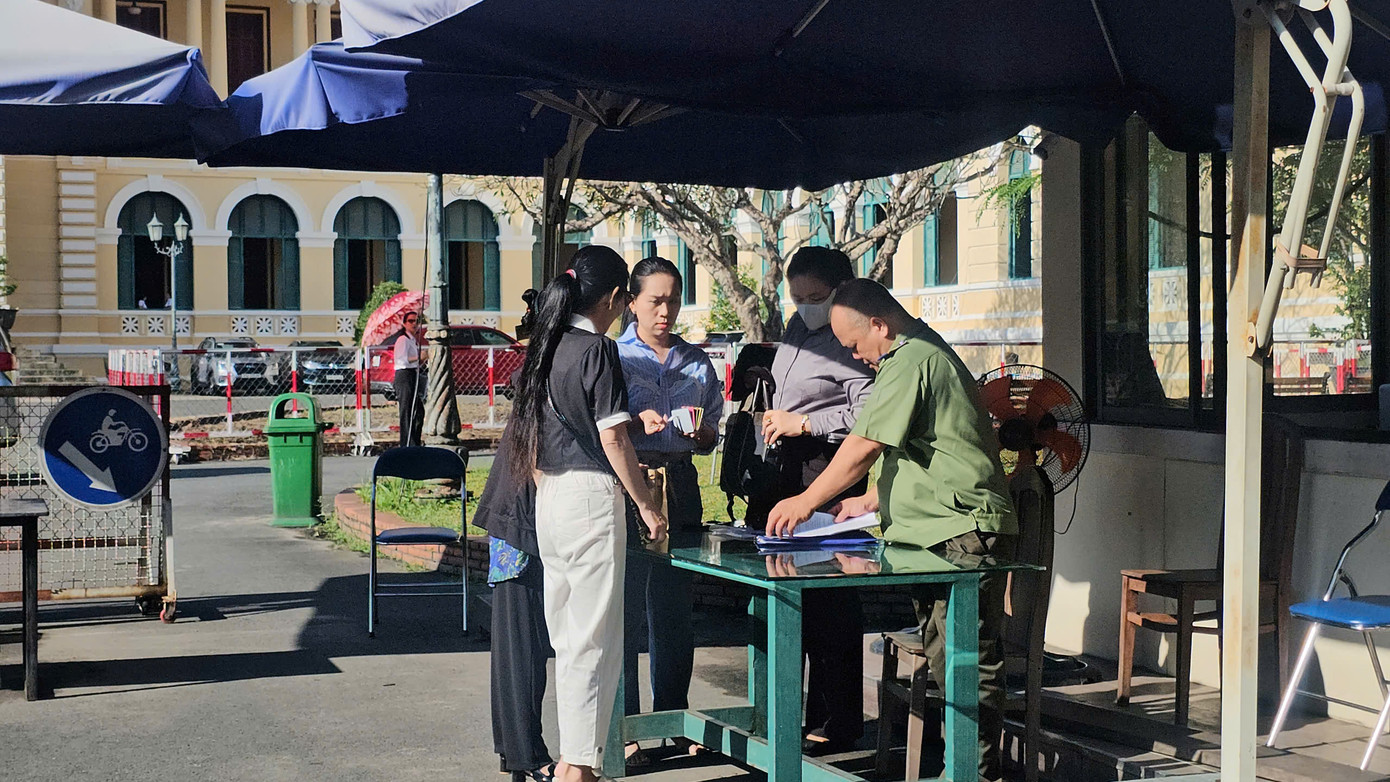 Bảo vệ tòa án làm thủ tục cho các bên tham gia phiên họp.