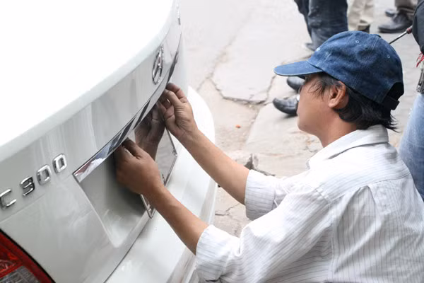 Đo khoảng cách để đục lỗ trước khi đeo biển số. Chuẩn bị cho việc đeo biển 5 số