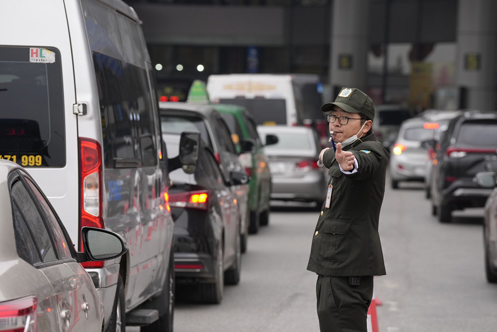 Lực lượng an ninh sân bay Nội Bài vất vả điều tiết phương tiện vào khu vực nhà ga nhằm giảm ùn tắc. Lực lượng an ninh sân bay Nội Bài vất vả điều tiết phương tiện vào khu vực nhà ga nhằm giảm ùn tắc.