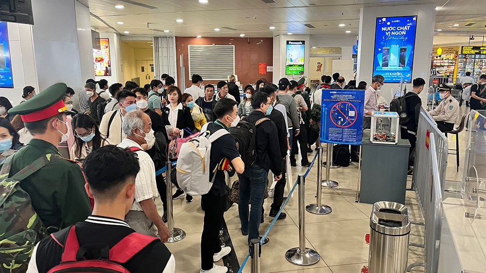 Hành khách rời Hà Nội xếp hàng làm thủ tục lên máy bay.