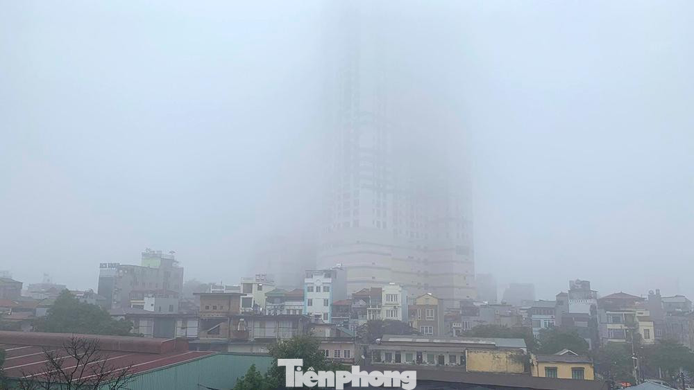 Toà nhà Mipec ở đầu cầu Long Biên “biến mất” trong sương mù.