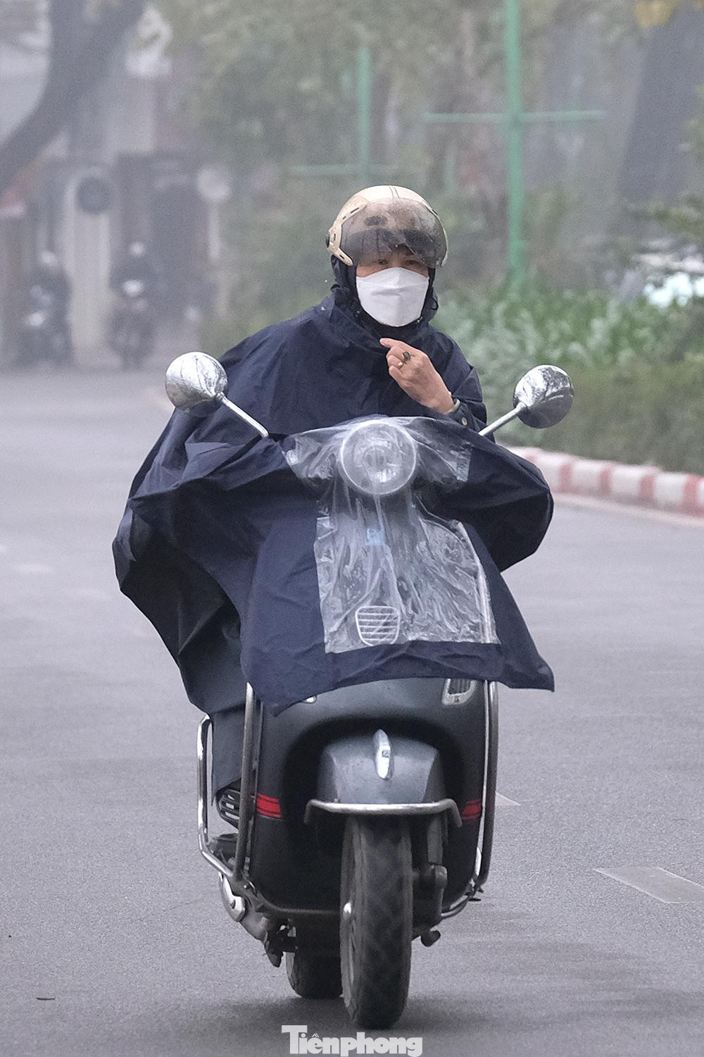 Sương mù mờ mịt vào buổi sáng khiến người tham gia giao thông phải khoác thêm áo mưa để bớt lạnh giá và ẩm ướt.