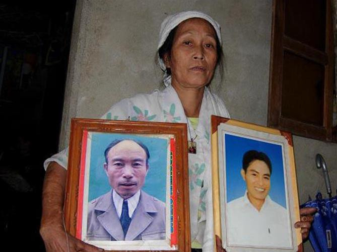 Bà Lê Thị Hoàn ôm di ảnh chồng và con trai vừa mới chết Bà Lê Thị Hoàn ôm di ảnh chồng và con trai vừa mới chết