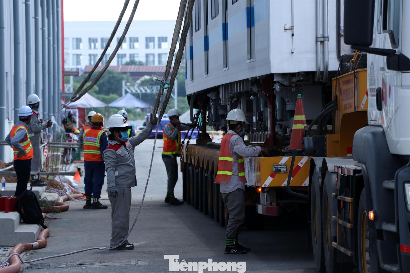 Những sợi cáp cẩu được móc cẩn thận vào toa tàu Metro trước khi nhấc lên khỏi xe siêu trường siêu trọng. Những sợi cáp cẩu được móc cẩn thận vào toa tàu Metro trước khi nhấc lên khỏi xe siêu trường siêu trọng.