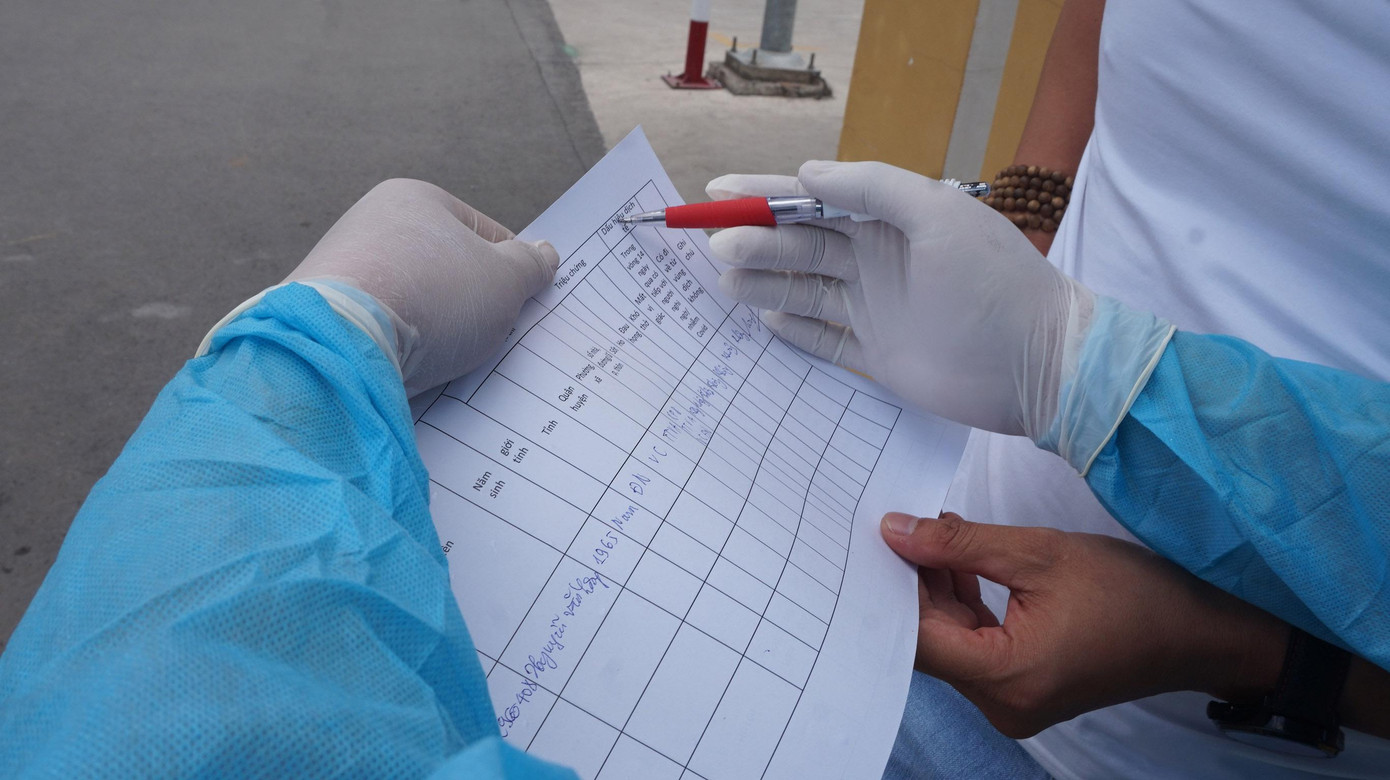 Nhân viên y tế lưu thông tin tài xế di chuyển qua chốt kiểm dịch. Nhân viên y tế lưu thông tin tài xế di chuyển qua chốt kiểm dịch.