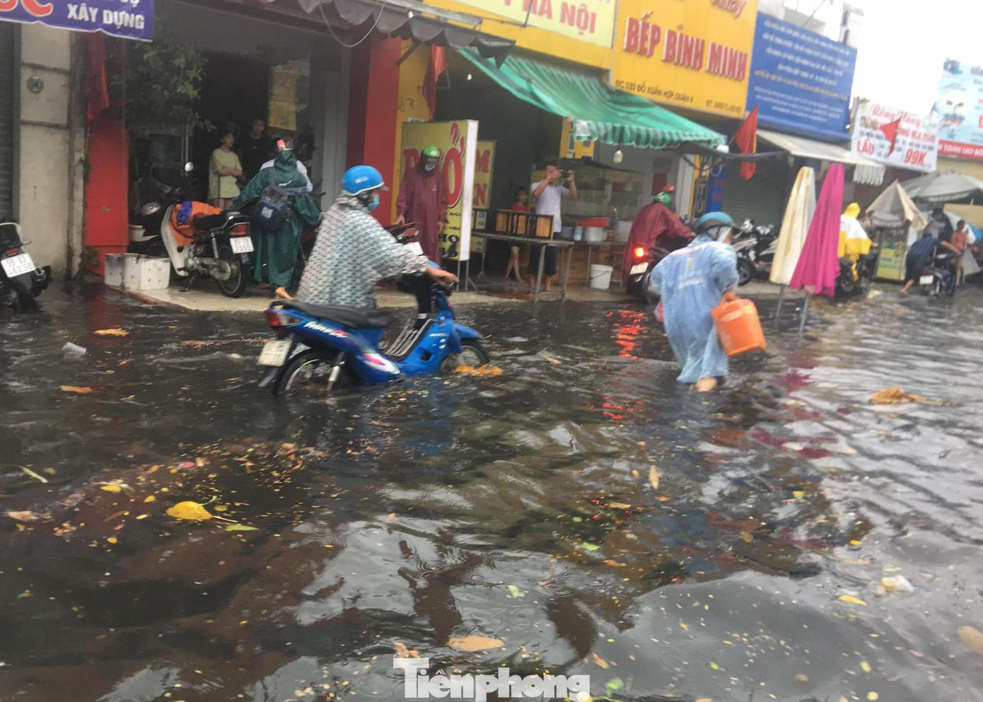 Xe chết máy giữa đường ngập sâu khiến người dân phải hì hục đẩy qua dòng nước đen ngòm về nhà.