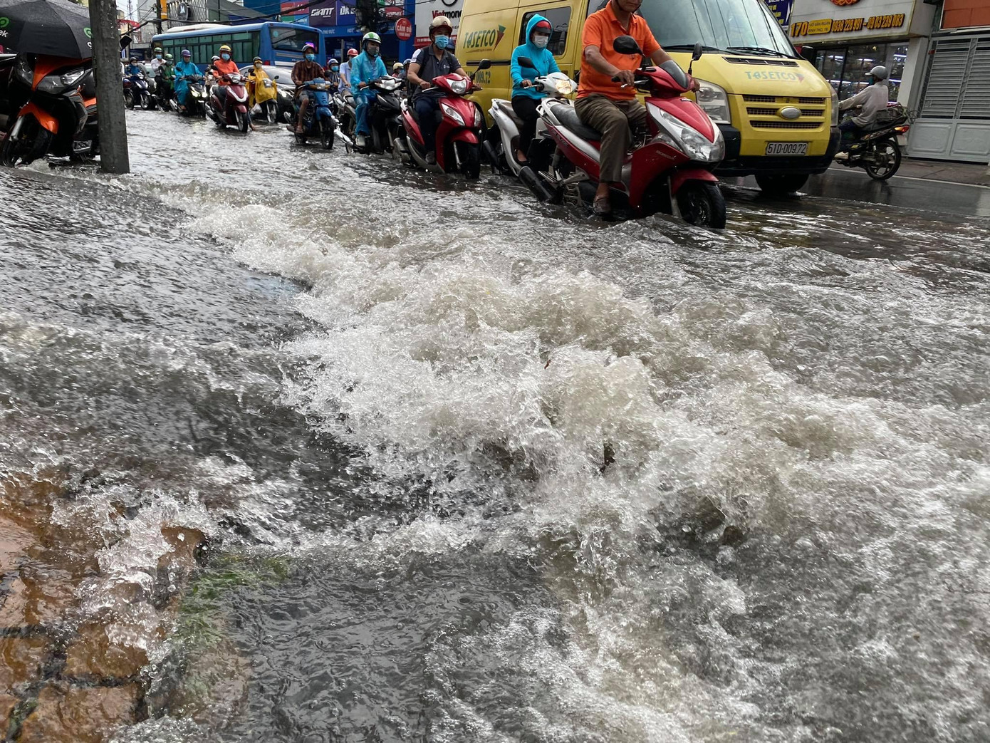 Nước từ các con hẻm đổ ra đường chính Kha Vạn Cân nhưng không có lối thoát nên chảy tràn trên mặt đường.