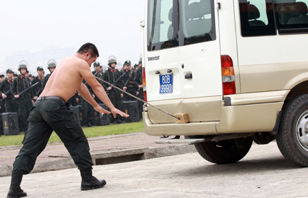 Trình diễn kỹ thuật đặt cây sắt vào yết hầu, dùng lực cơ thể đẩy xe ô tô 16 chỗ. Trình diễn kỹ thuật đặt cây sắt vào yết hầu, dùng lực cơ thể đẩy xe ô tô 16 chỗ