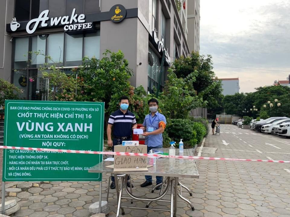 Tại bàn giao nhận hàng ở các chốt "vùng xanh" đều trang bị cồn rửa tay, sát khuẩn cho cư dân và shipper. Trong hình là "vùng xanh" tại chung cư 987 Tam Trinh (phường Yên Sở, quận Hoàng Mai).