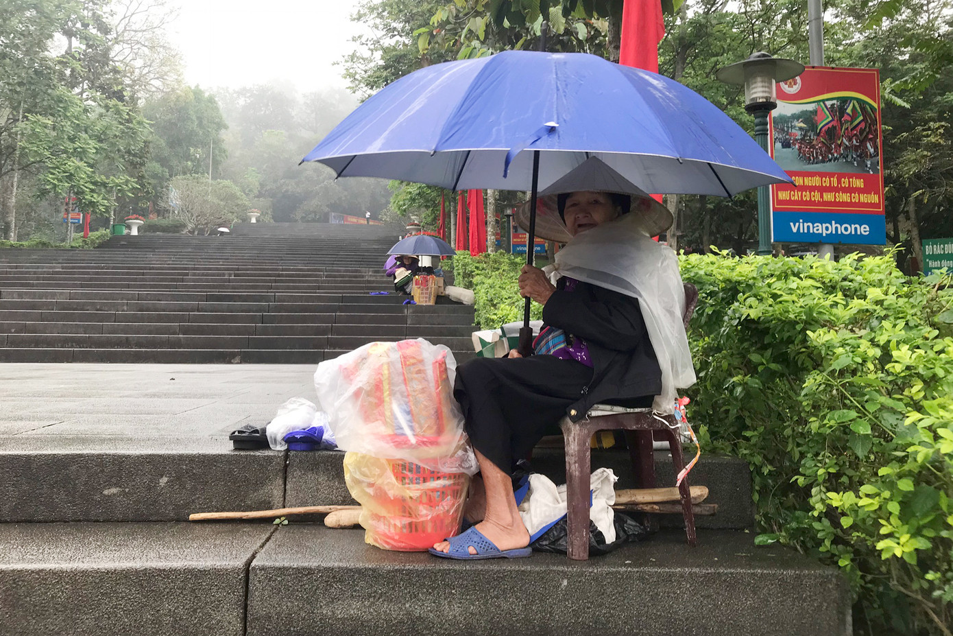 Một cụ già ngồi bán hàng rong trên lối đi lên cổng Đền Hùng. Một cụ già ngồi bán hàng rong trên lối đi lên cổng Đền Hùng.