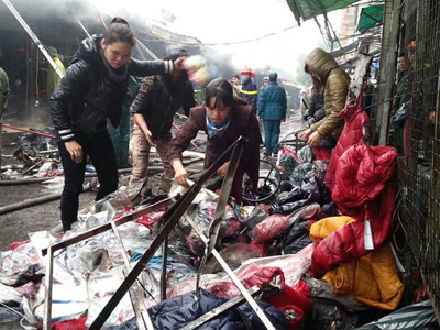 Tiểu thương đào bới tìm những bộ quần áo còn sử dụng được . Tiểu thương đào bới tìm những bộ quần áo còn sử dụng được