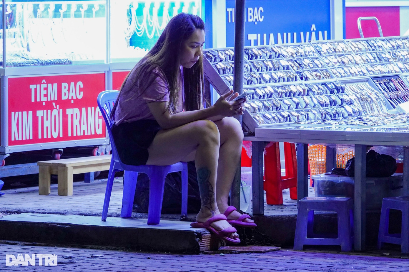 Nhiều cửa hàng vắng bóng người qua lại, người bán hàng ngồi xem điện thoại để chống buồn ngủ.