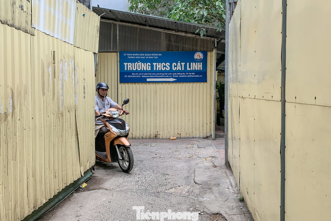 Lối đi vào trường nhỏ và hẹp, xung quanh là hàng rào tôn.