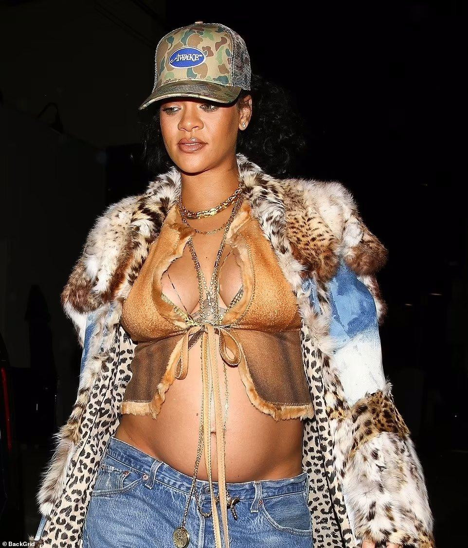 &quot;Nữ ca sĩ giàu nhất thế giới&quot; phối áo crop-top buộc dây với quần jean ống rộng, kết hợp áo khoác lông chắp vá, mũ rằn ri và sandal cao gót. Như thường lệ, cô đeo nhiều dây chuyền chiều dài khác nhau.