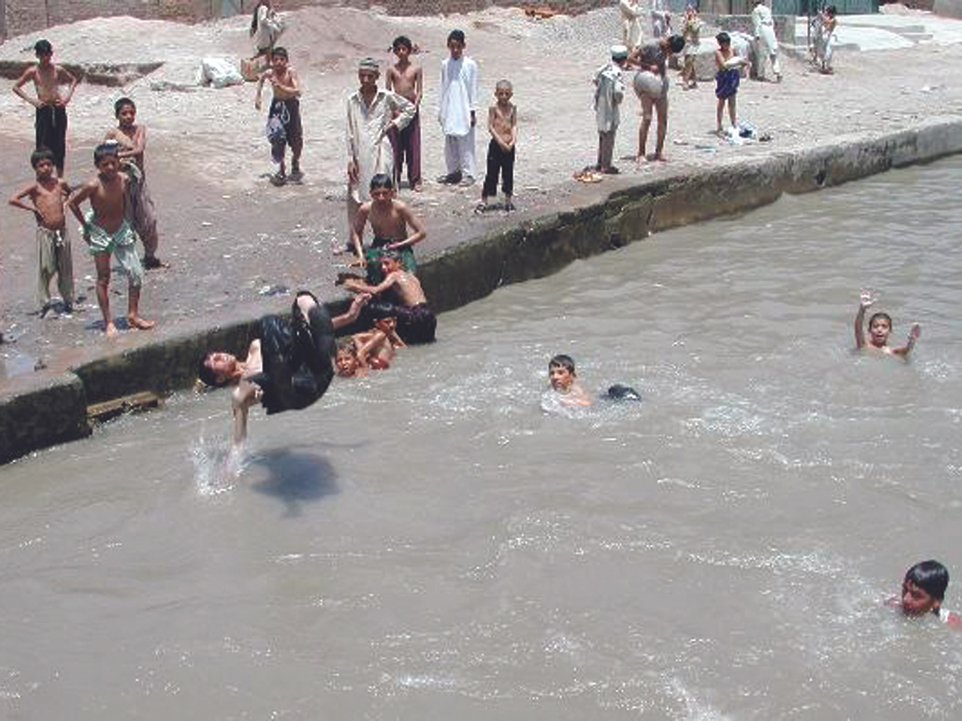 Các con kênh ở Peshawar, thành phố phía tây bắc Pakistan luôn chật kín người dân đến tắm để đối phó cái oi bức của thời tiết