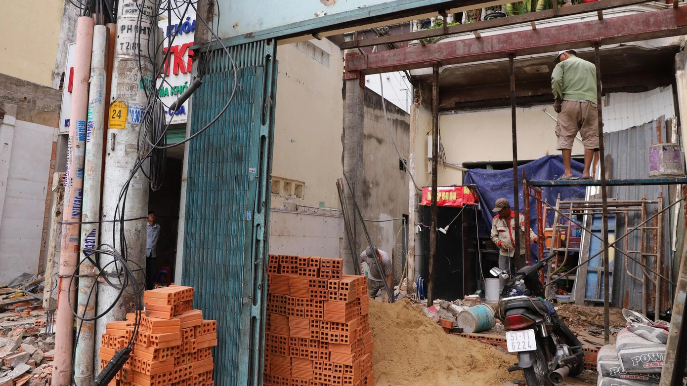 Song song với quá trình tháo dỡ, các hộ dân cũng mua gạch, xi măng và thuê người đến xây, sửa phần diện tích nhà còn lại.