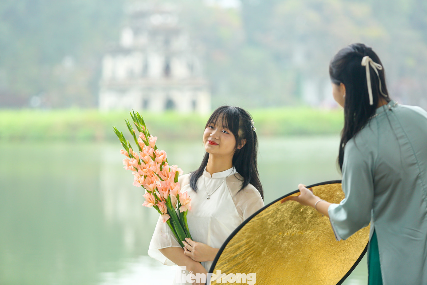 Những thiếu nữ duyên dáng, cầm trên tay nhành hoa xinh xắn, tạo dáng chụp hình đã tạo nên không khí tưng bừng sắc xuân xung quanh hồ Hoàn Kiếm.
