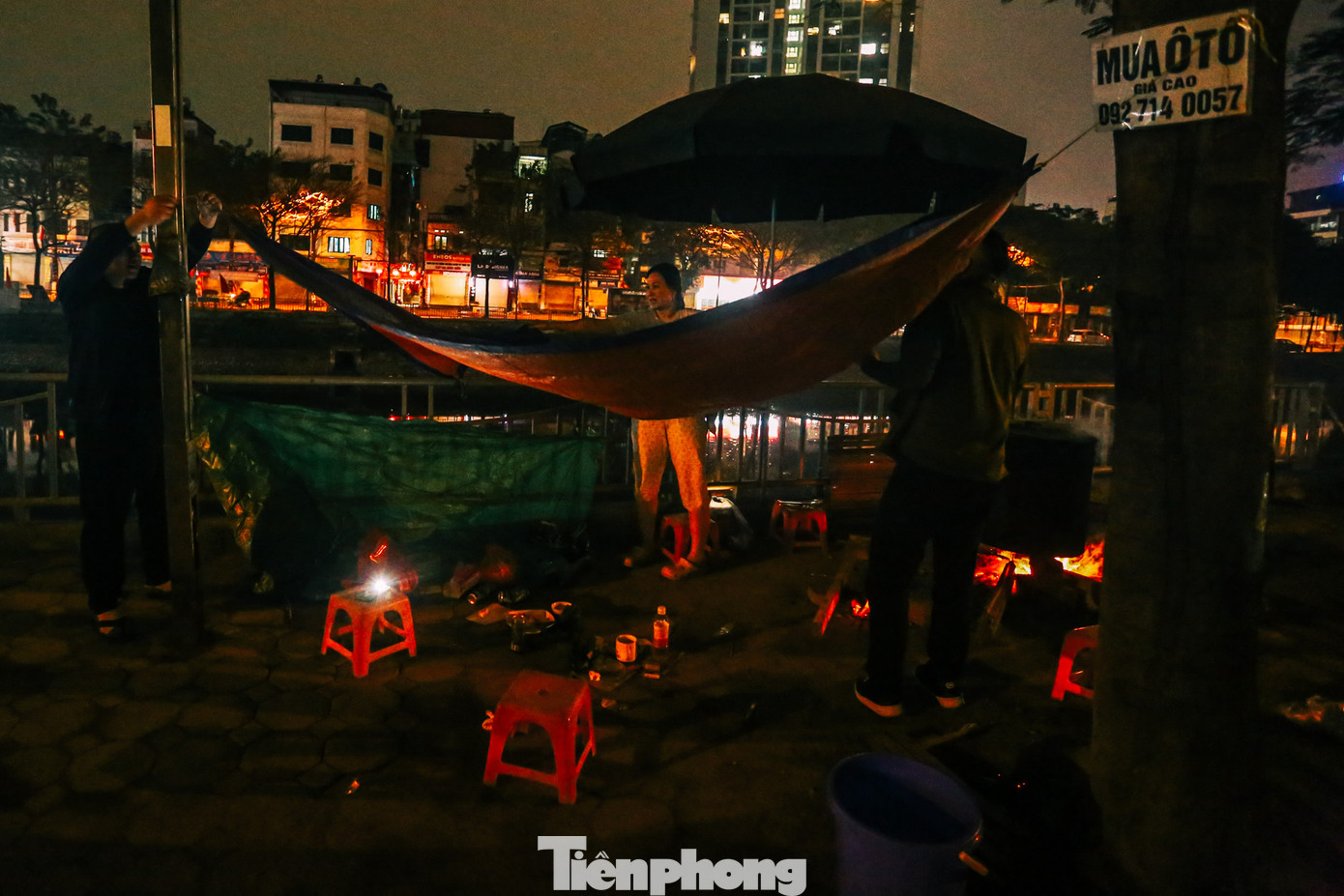 Gia đình căng bạt tránh thời tiết mưa phùn, gió rét ở Hà Nội, để có thể xuyên đêm ngồi quây quần canh nồi bánh chưng đến khi được vớt.