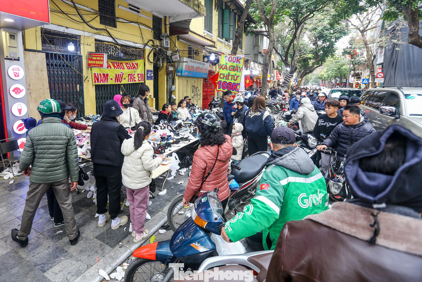 Ghi nhận của PV tại phố Hàng Bông (quận Hoàn Kiếm) vào chiều 30 Tết, hàng chục sạp quần áo bày bán trên vỉa hè, treo biển "xả kho giày", "xả hàng quần áo", "thanh lý cửa hàng" thu hút khá đông khách.