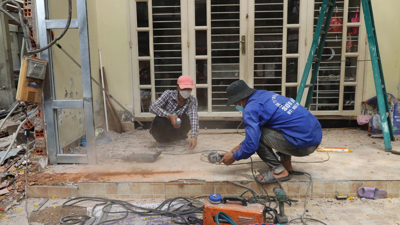 Công nhân tháo dỡ nhà dùng máy cắt đĩa tạo ranh trước thềm một ngôi nhà phải lùi vào gần 4m so với lộ giới hiện hữu.