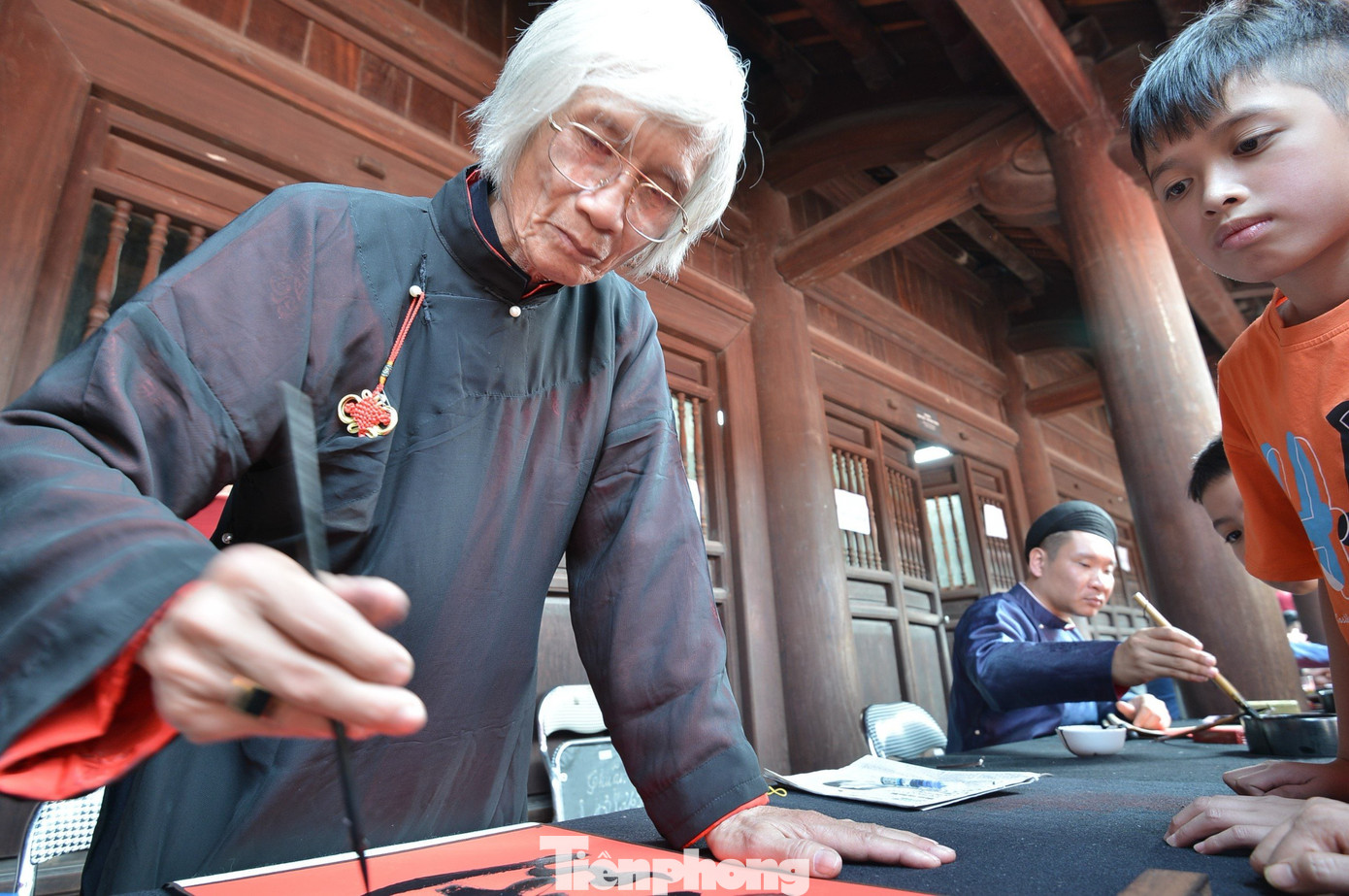 Trong Văn Miếu có 5 ông đồ được bố trí phục vụ người dân. Để xin được chữ, người dân mua mỗi tờ giấy đỏ được bán với giá 100.000 đồng một tờ và xếp hàng để đến lượt.