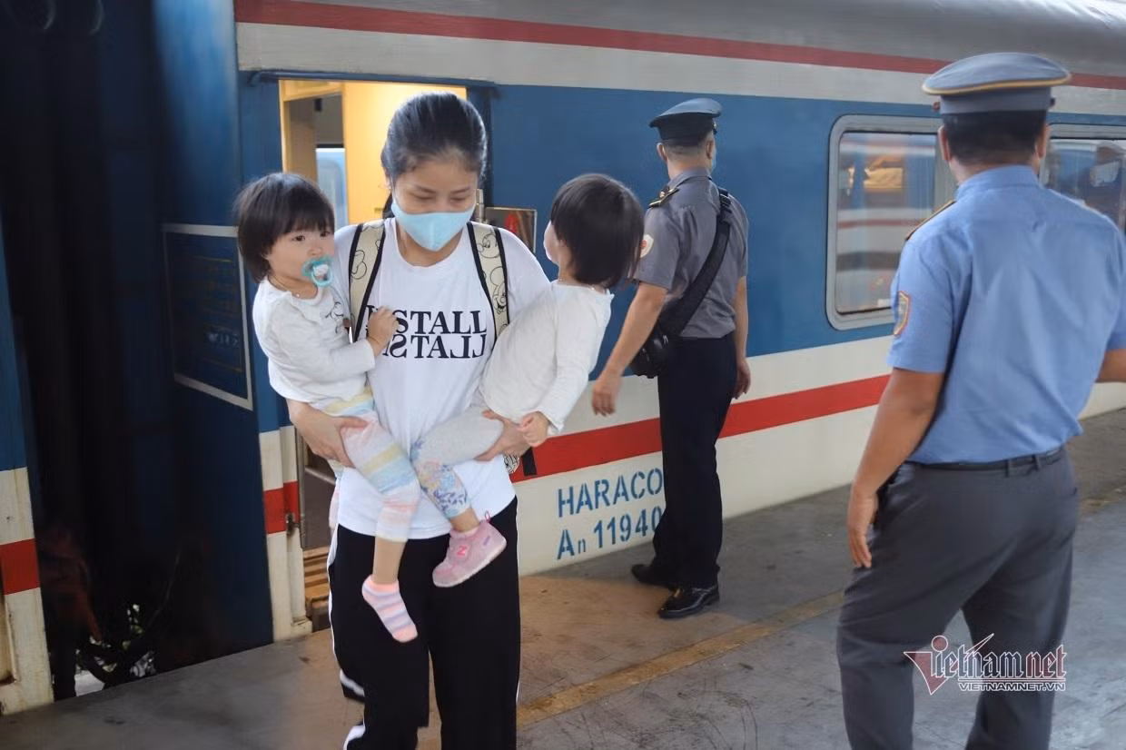 Một hành khách đưa hai con nhỏ trở lại TPHCM sau thời gian dài gửi con ở quê cho ông bà chăm sóc