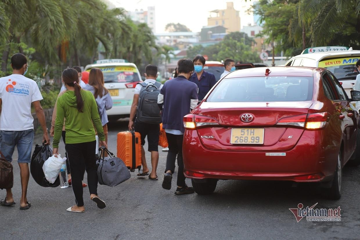Trong ảnh, hành khách gọi ứng dụng xe công nghệ để về nhà. Tất cả hành khách đến TPHCM đều không phải cách ly tập trung mà được về nhà và tự theo dõi sức khỏe