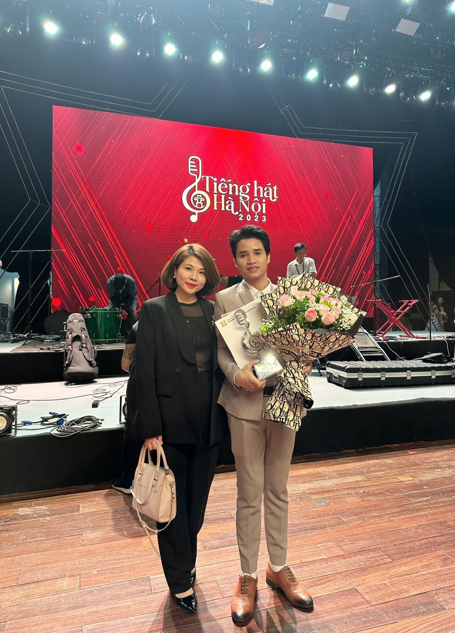 Hồ Văn Kãnh chụp ảnh cùng cô giáo trưởng khoa thanh nhạc trường Đại học Văn hóa Nghệ thuật Quân đội.