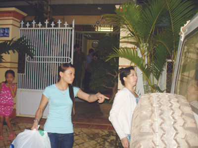 Thủ quỹ An (áo trắng) bị dẫn giải lên xe công an... 