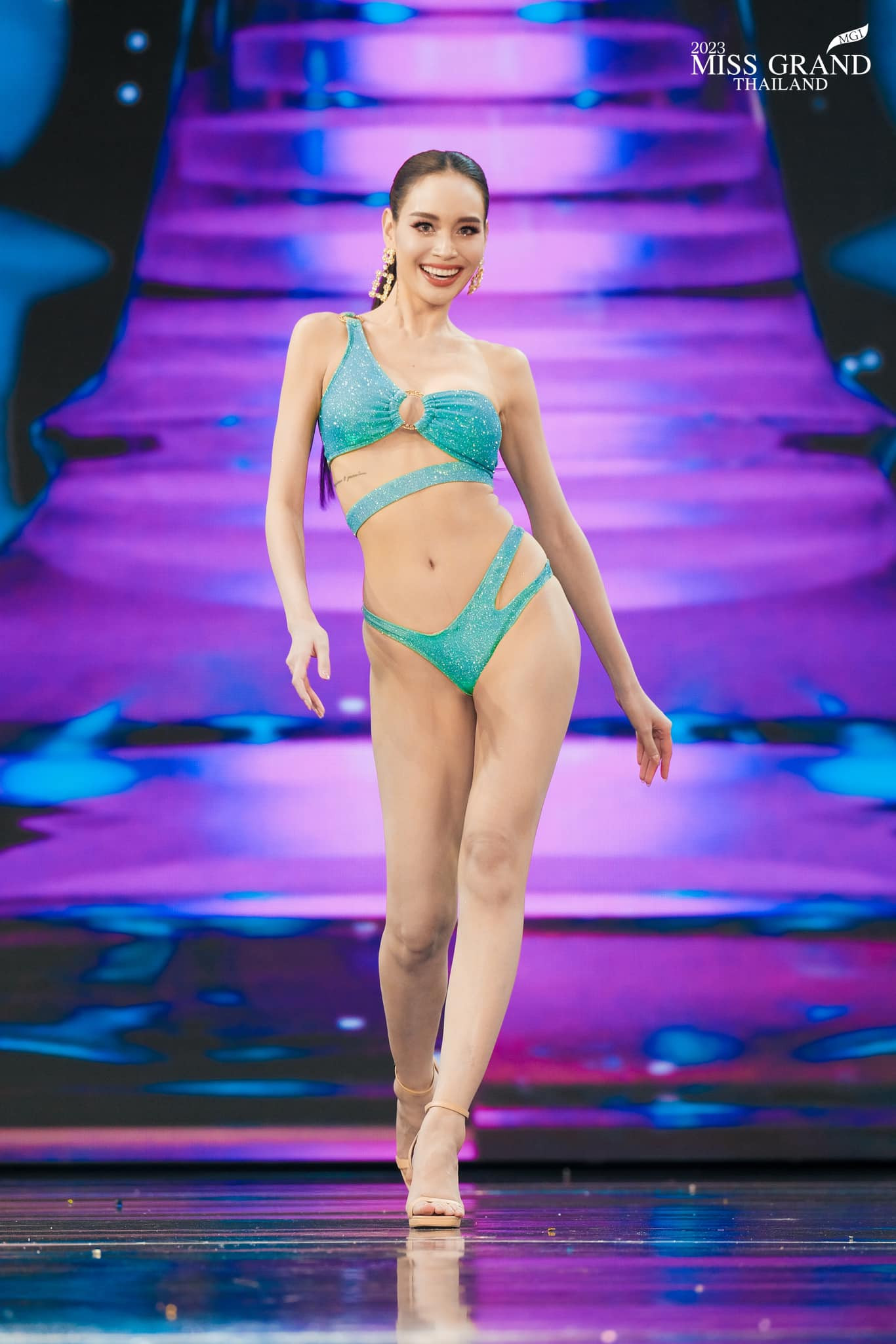 Người đẹp Pimjira Charoenlak - Miss Grand Bangkok khoe hình thể và đôi chân dài trong phần thi bikini. Năm 2014, cô từng tham gia bộ phim về đề tài thi sắc đẹp có tên Cuộc chiến sắc đẹp (Songkram Nang Ngarm). Đây là một trong những bộ phim nổi tiếng khai thác những câu chuyện hậu trường ở các cuộc thi sắc đẹp và cũng được một bộ phận khán giả Việt Nam biết đến.