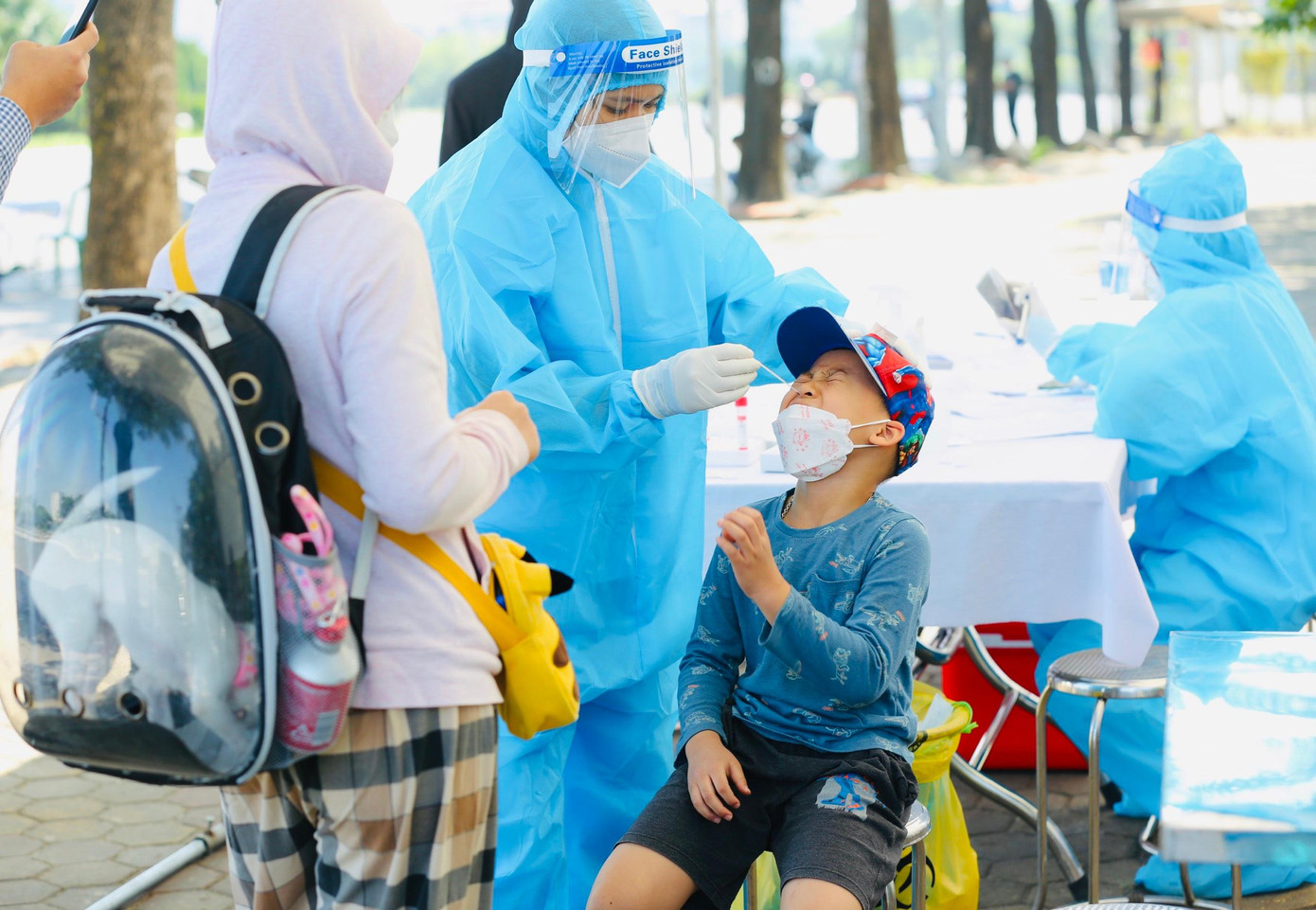 Vừa xét test nhanh xong COVID-19 tại cổng sân Mỹ Đình, bé Hải Đăng học lớp 1G trường tiểu học Dịch Vọng A rất phấn khởi khi lần đầu được theo bố mẹ đi xem bóng đá tại sân.