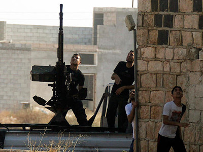 Một tay súng nổi dậy nhắm bắn máy bay chiến đấu của Không lực Syria. Ảnh: Goran Tomasevic