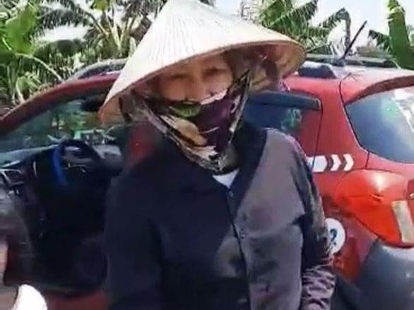 Người phụ nữ chở học sinh lớp 1 đi khỏi cổng trường.