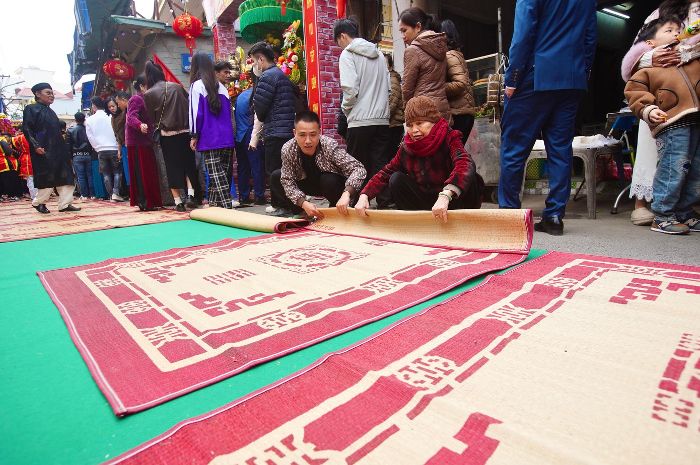 Người dân thu chiếu sau khi kiệu Thánh đi qua.