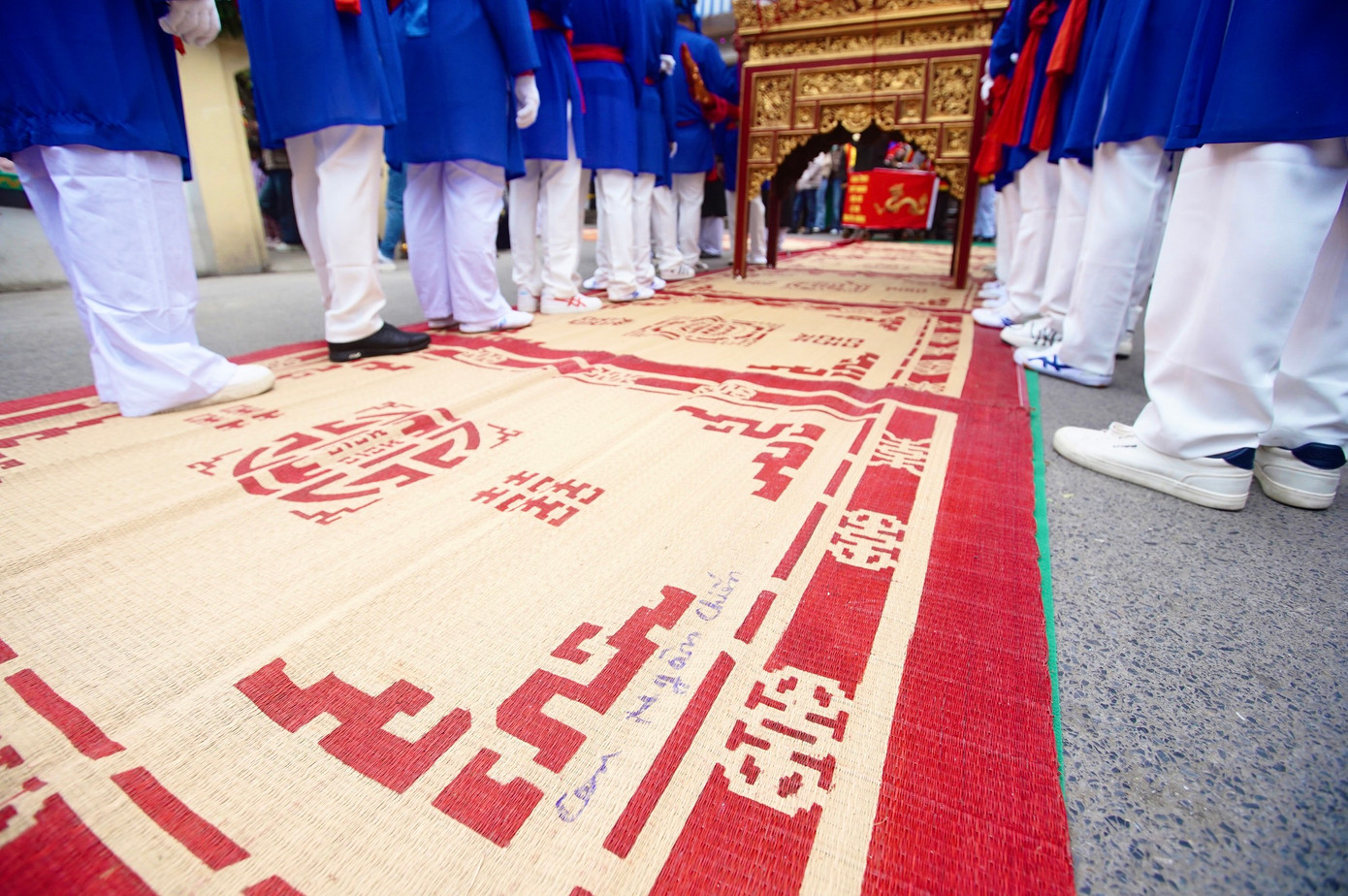 Nhiền người dân viết tên đánh dấu lên chiếu để sau khi kiệu Thánh đi qua còn thu về nhà.