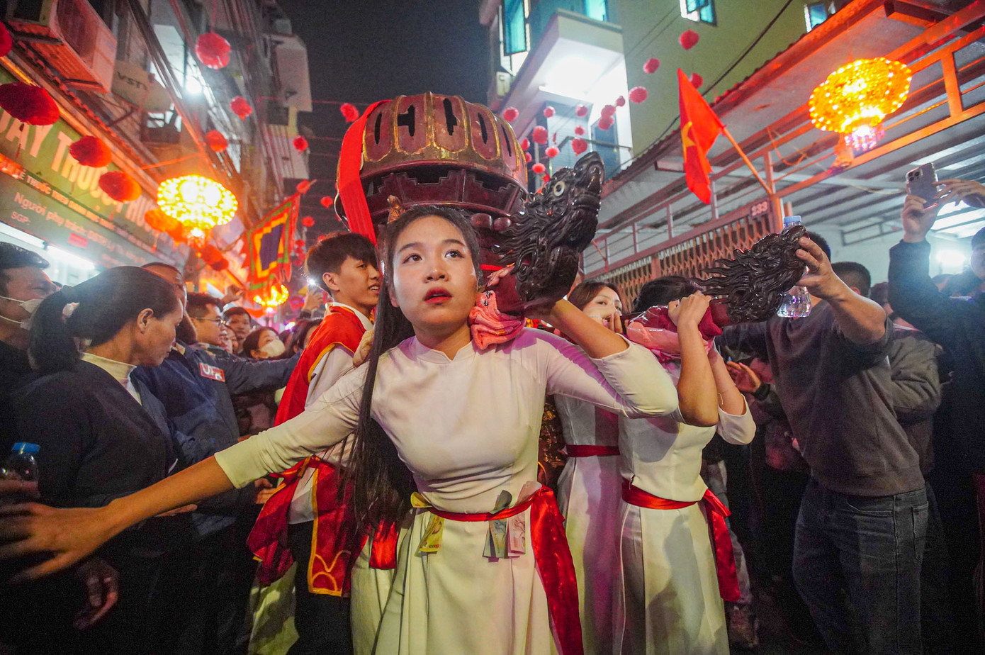 Các thiếu nữ trong trang phục trắng cố giữ thăng bằng cho kiệu.