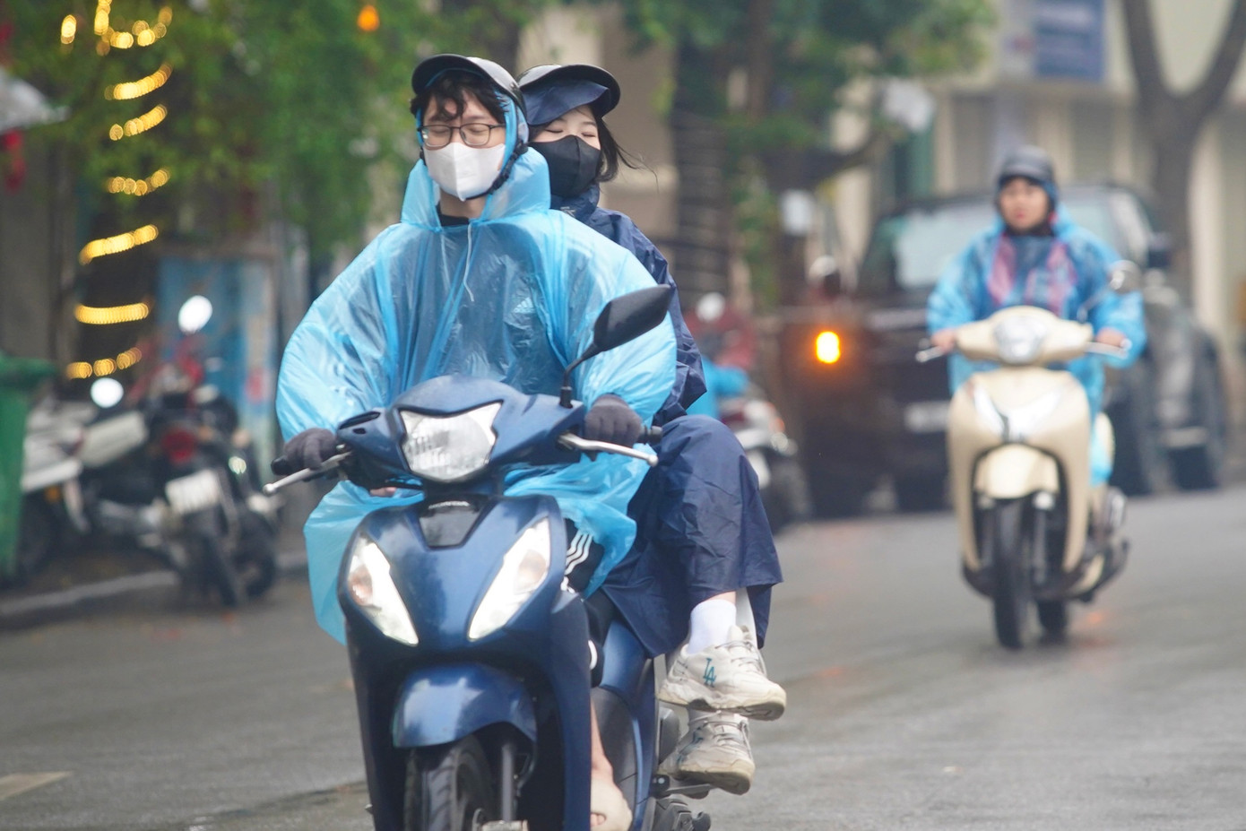 Người Hà Nội ra đường với nhiều lớp áo ấm kèm theo áo mưa, tầm nhìn hạn chế.