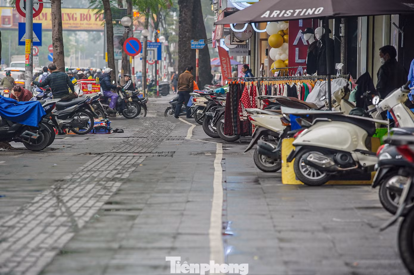 Phần lớn vỉa hè được các hộ kinh doanh tận dụng bày bán quần áo, đỗ xe máy.