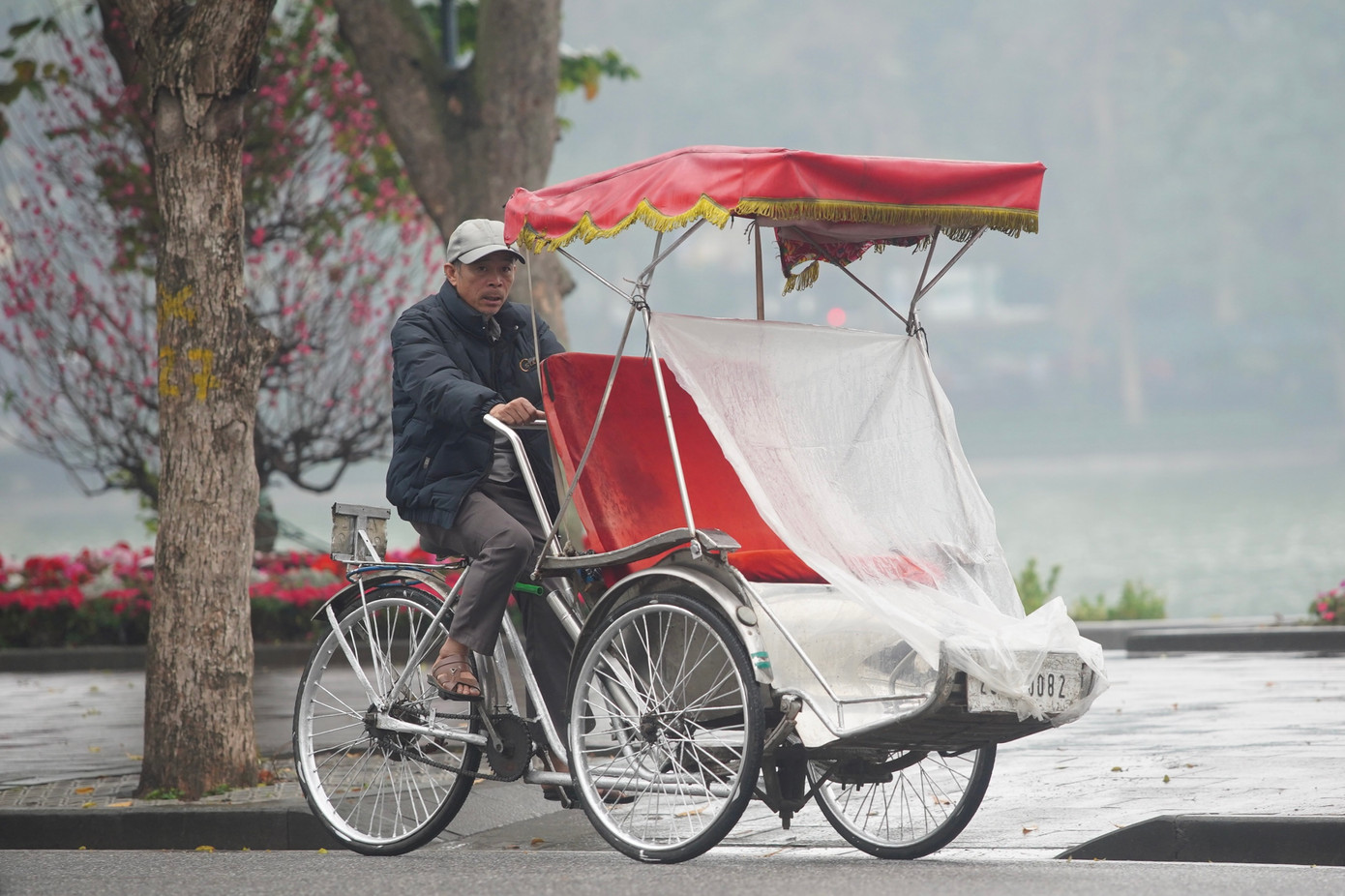 Xích lô dùng bạt che mưa chỗ ngồi trước khi đón khách.