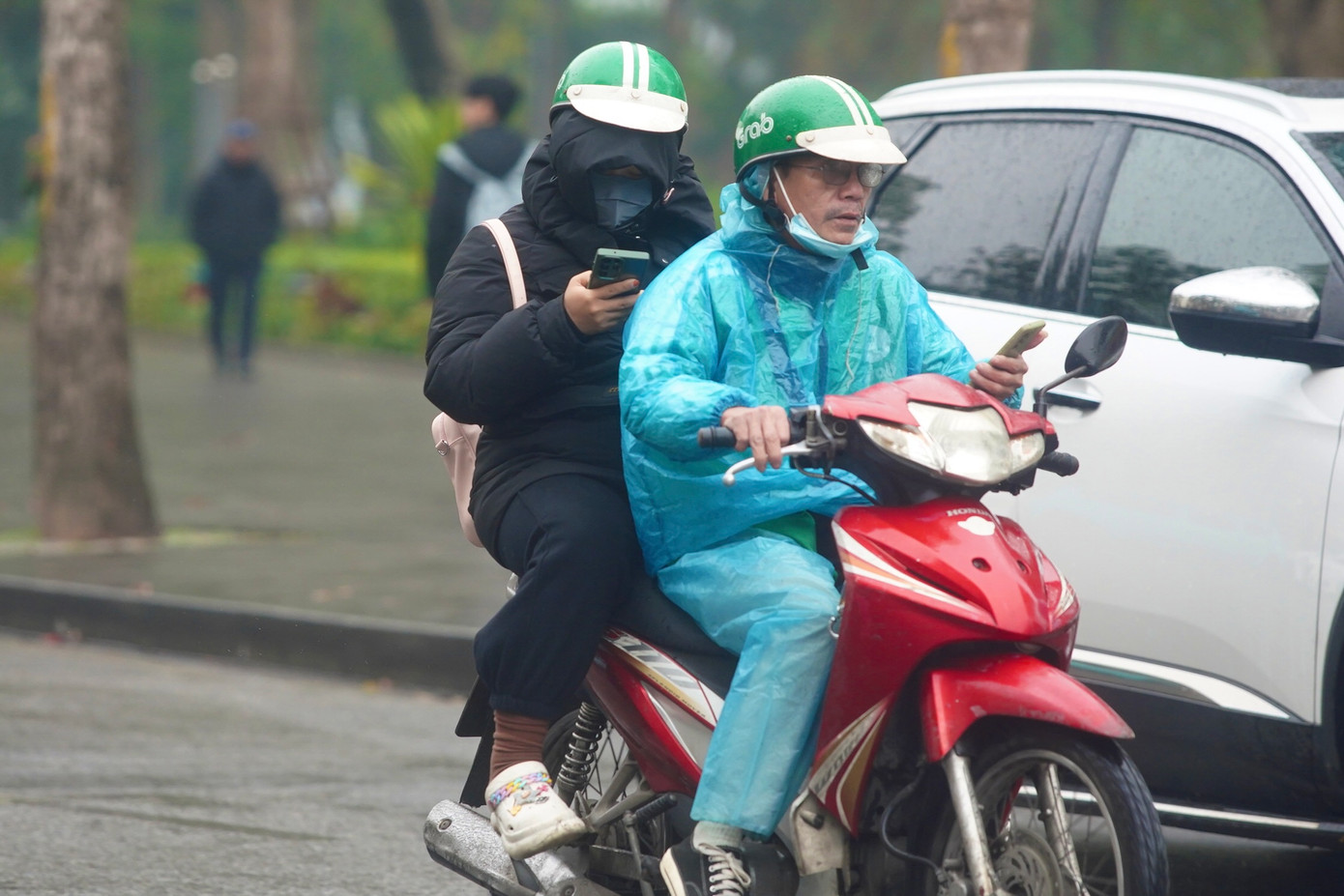 Người Hà Nội ra đường với nhiều lớp áo ấm kèm theo áo mưa, tầm nhìn hạn chế.