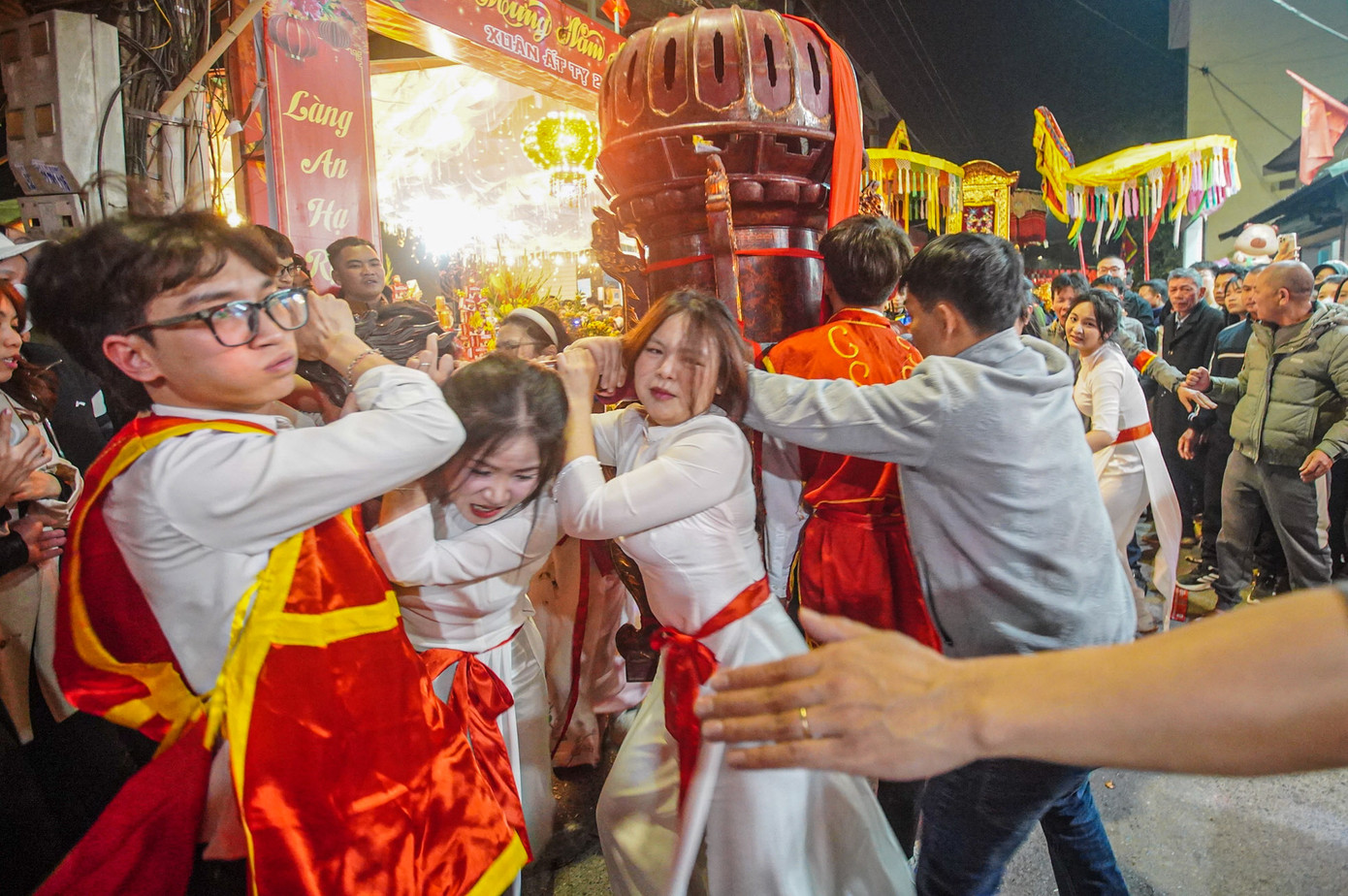 Các thiếu nữ trong trang phục trắng cố giữ thăng bằng cho kiệu.