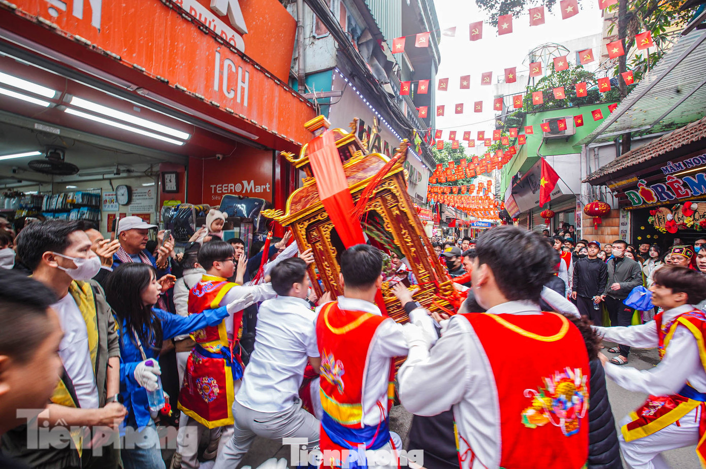Một người khiêng kiệu bị ngã, kiệu vừa nghiêng thì ngay lập tức nhiều người lao vào đỡ dựng lên.