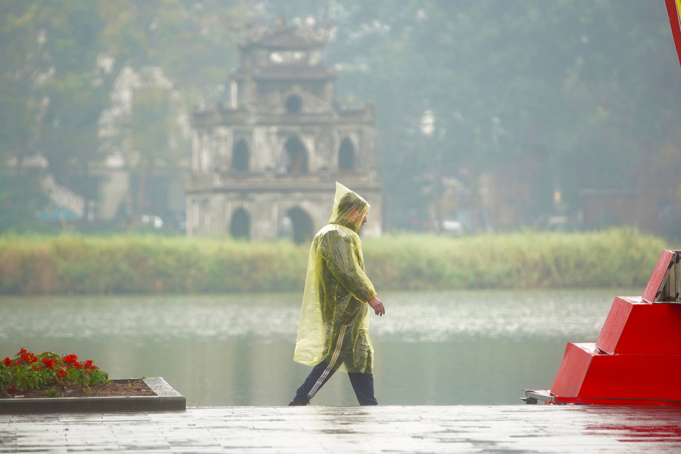 Người dân mặc áo mưa tập thể dục sáng nay (6/2).